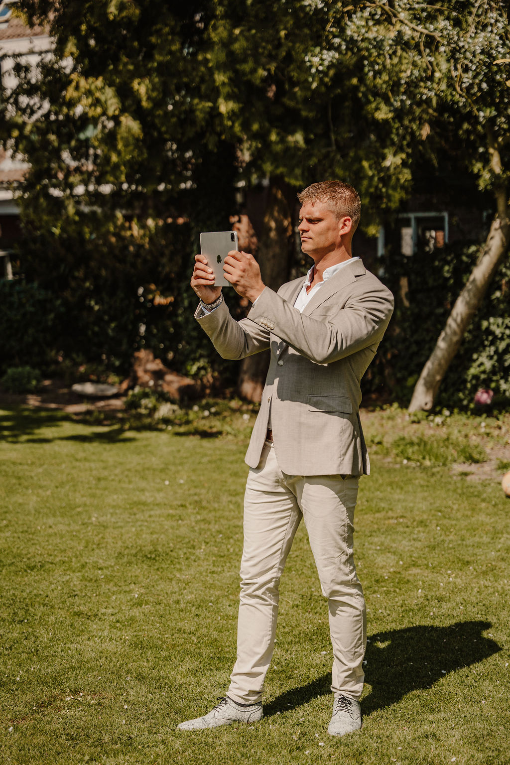 De taxateur fotografeert de buitenzijde en tuin van een woning
